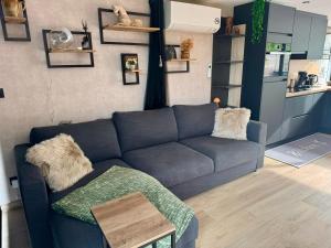 a living room with a blue couch and a table at B&B Wellness Garden in Herzele