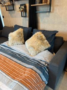 a couch with two pillows on top of it at B&B Wellness Garden in Herzele +39 photos