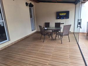 a dining room with a table and chairs on a floor at Casa Boraceia Litoral Norte SP in São Sebastião