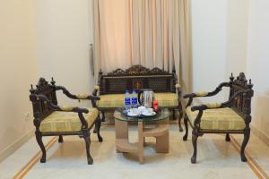 a room with two chairs and a table and a bed at Majestic BnB in Karachi