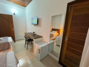 a small room with a desk and a bedroom at Hotel Ipe in Barreirinhas