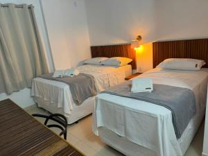 two beds in a hotel room with a laptop on them at Hotel Ipe in Barreirinhas
