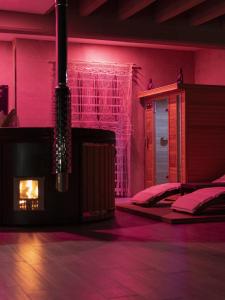 a bedroom with a fireplace and pink lighting at Villa Margares in Valenzano
