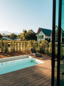 a pool with a chair next to a house at Pai Prestige - Luxury Pool Villas in the centre of Pai in Pai