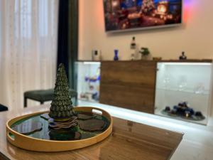 La Luna Premium Deluxe Apartment with Pool & Jacuzzi, Bikes and Covered Parking في Našice: شجرة عيد الميلاد الصغيرة موضوعة على طاولة زجاجية