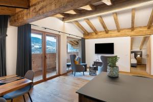 a living room with a table and chairs and a television at Alpin Chalet Samer Apt Fürstenblick in Sarntal