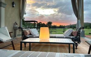 a patio with a table and chairs and a sunset at Beautiful Home In Ansedonia in Ansedónia