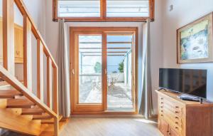 a living room with a sliding glass door and a television at Stunning Home In Carloforte With Wifi in Carloforte