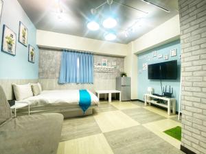 a bedroom with a bed and a tv and a couch at 一中街藻宿 in Taichung