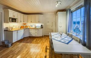 Una cocina con gabinetes blancos y una ventana grande. en Nice Home In Braskereidfoss With Wifi, en Skårå