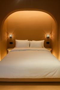 a large white bed with two lights on it at Marabou Unique Stay in Thessaloniki