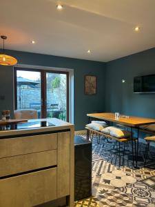 a kitchen with blue walls and a table and chairs at Meadow Cottage Cambridge in Trumpington