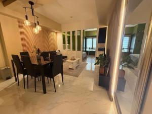 GM City Rentals في مانداوي سيتي: غرفة طعام وغرفة معيشة مع طاولة وكراسي