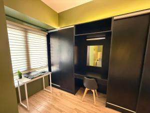 GM City Rentals في مانداوي سيتي: غرفة بها مكتب وكرسي ونافذة