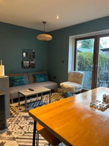 a living room with a couch and a table at Meadow Cottage Cambridge in Trumpington
