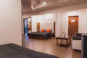 a bedroom with a bed with orange pillows on it at Hotel Morainic Hills Mall Road Bhagsunag in McLeod Ganj