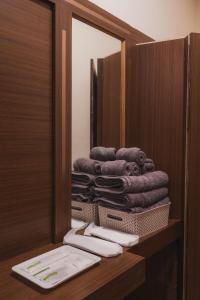 a pile of towels on a shelf in a bathroom at Hotel Morainic Hills Mall Road Bhagsunag in McLeod Ganj