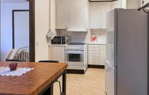 a kitchen with a white refrigerator and a table at 1 Bedroom Amazing Apartment In Hultsfred in Hultsfred