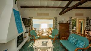 a living room with a table and chairs at Futura anima sarda, villa sul tramonto con piscina privata in Costa Paradiso