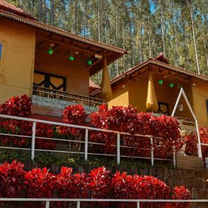 a house with red flowers in front of it at HolidayZ by Stayz Royale in Yercaud - Misty Woody Stay in Yercaud