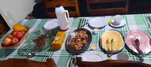 a table with a green and white table cloth with food on it at Pousada e Espaço de Eventos Rancho da Invernada in Bandeirantes