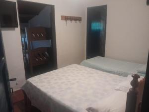 a small bedroom with two beds and a mirror at Pousada e Espaço de Eventos Rancho da Invernada in Bandeirantes