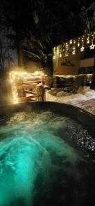 a hot tub with blue water at night with lights at Domek pod Kozińcem SAUNA JACUZZI Zakopane in Zakopane
