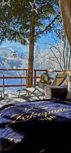 a bed with a blue blanket with a snow covered tree at Domek pod Kozińcem SAUNA JACUZZI Zakopane in Zakopane