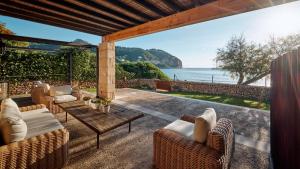 an outdoor patio with wicker furniture and a view of the ocean at Can Simoneta - Adults Only in Canyamel