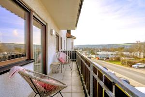 balcón con 2 sillas y vistas a la calle en ERB03 Apartment Wohlgefühl, en Michelstadt