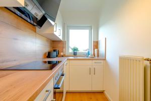 Una cocina con gabinetes blancos y una ventana. en ERB03 Apartment Wohlgefühl, en Michelstadt 2 fotos más