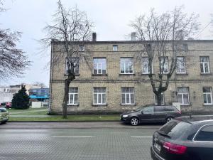 a large brick building with cars parked in front of it at Saulgrieži 7 in Ventspils
