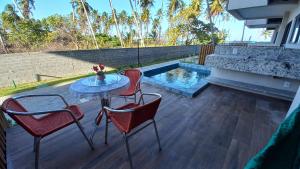 a patio with a table and chairs and a pool at Apto Pe na Areia com Piscina Privativa in Ipioca