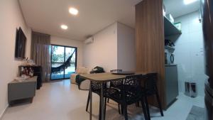 a kitchen and living room with a table and chairs at Apto Pe na Areia com Piscina Privativa in Ipioca