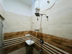 a bathroom with a sink and a light on the wall at ADH Amilia Nest in Mysore