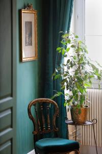 a green room with a chair and a potted plant at Villa La Poste 