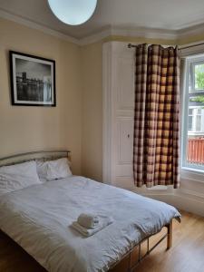 Un dormitorio con una cama con sombrero y una ventana. en Private Room, Sunderland City, en Sunderland