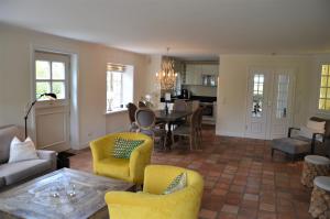 a living room with yellow chairs and a table at LITZKOW 15005 in Morsum