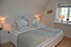 a bedroom with a white bed with pillows on it at LITZKOW 15005 in Morsum