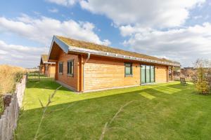 una piccola casa in legno con un ampio cortile di Huus Goos a Kating