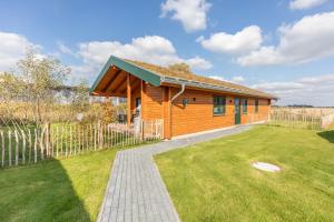 una piccola casa in legno con un prato di Huus Katteker a Kating