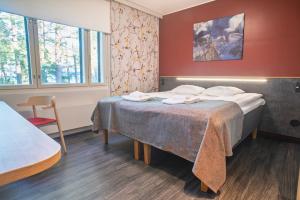 ein Hotelzimmer mit einem Bett, auf dem Handtücher liegen in der Unterkunft Hotel Linnasmäki in Turku