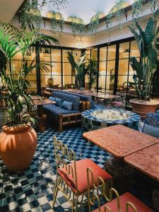 a lobby with tables and chairs and potted plants at Wilde Aparthotels Lisbon Liberdade in Lisbon