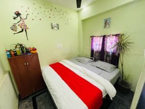 迈索尔ADH Amilia Nest的一间卧室配有一张带红白毯子的床