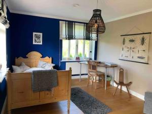 a bedroom with a bed and a table and a blue wall at EinfachSein Zimmer in Trittau