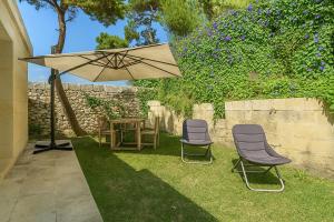 twee stoelen en een tafel onder een paraplu bij Hotiday Otranto Porto in Otranto