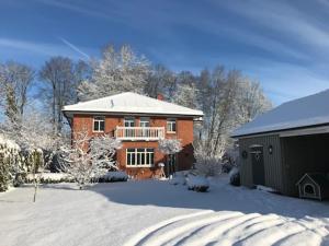 una grande casa di mattoni con il tetto coperto di neve di EinfachSein a Trittau