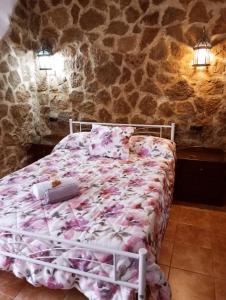 una camera da letto con un letto in un muro di pietra di Casa Pepa ad Algar Altre 53 foto