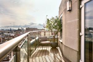 a balcony with a chair and a view of a city at Radisson Blu Hotel, London Bond Street in London