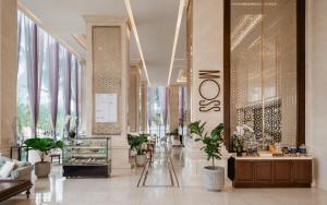 eine Lobby mit Topfpflanzen in einem Gebäude in der Unterkunft Meliá Vinpearl Danang Riverfront in Đà Nẵng
